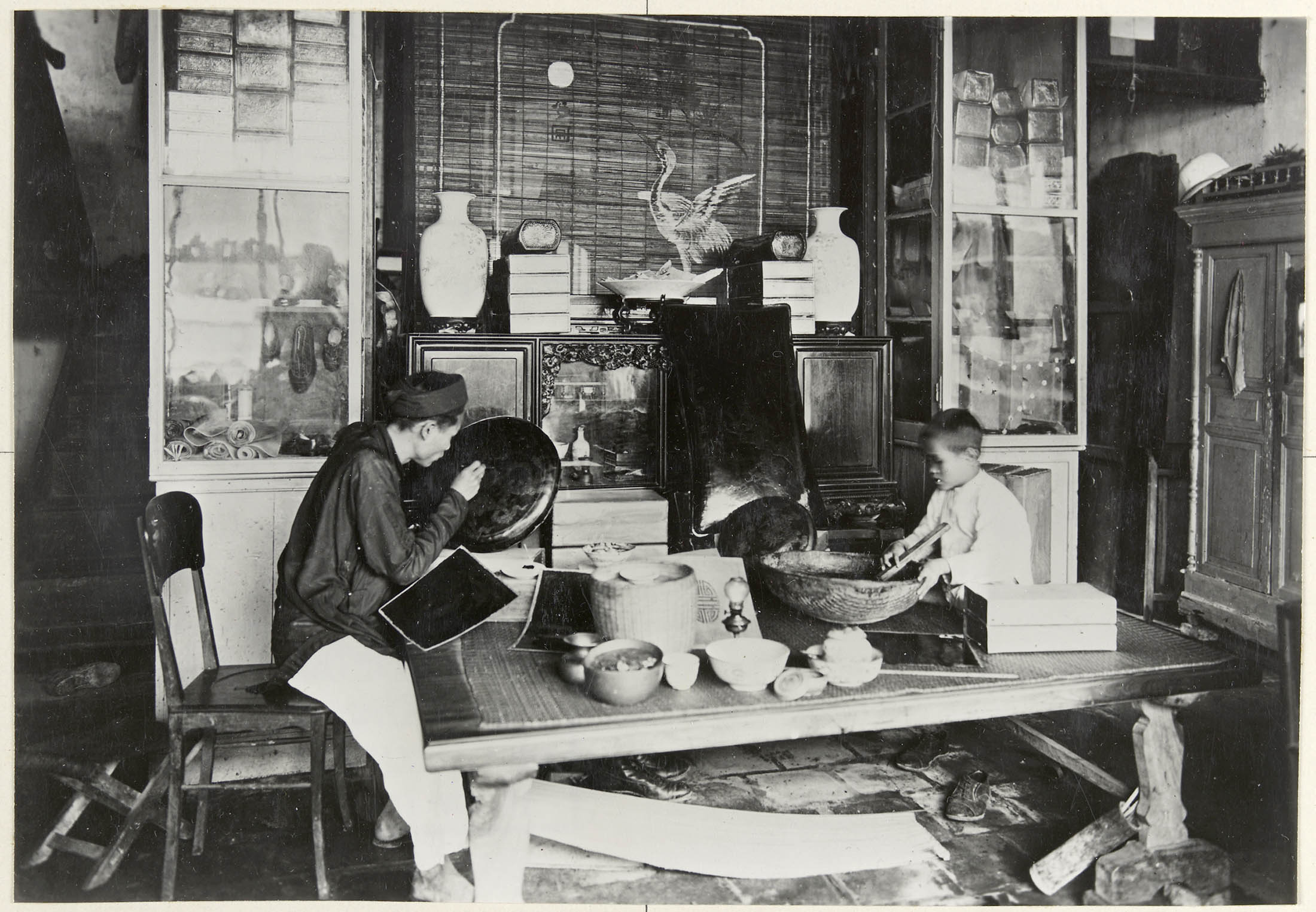 Laquage des coussins, vue de l’intérieur de l’atelier du laqueur (1921-1935). Photographie de Busy (Léon) (1874-?) provenant du fonds de l’Agence économique de la France d’outre-mer