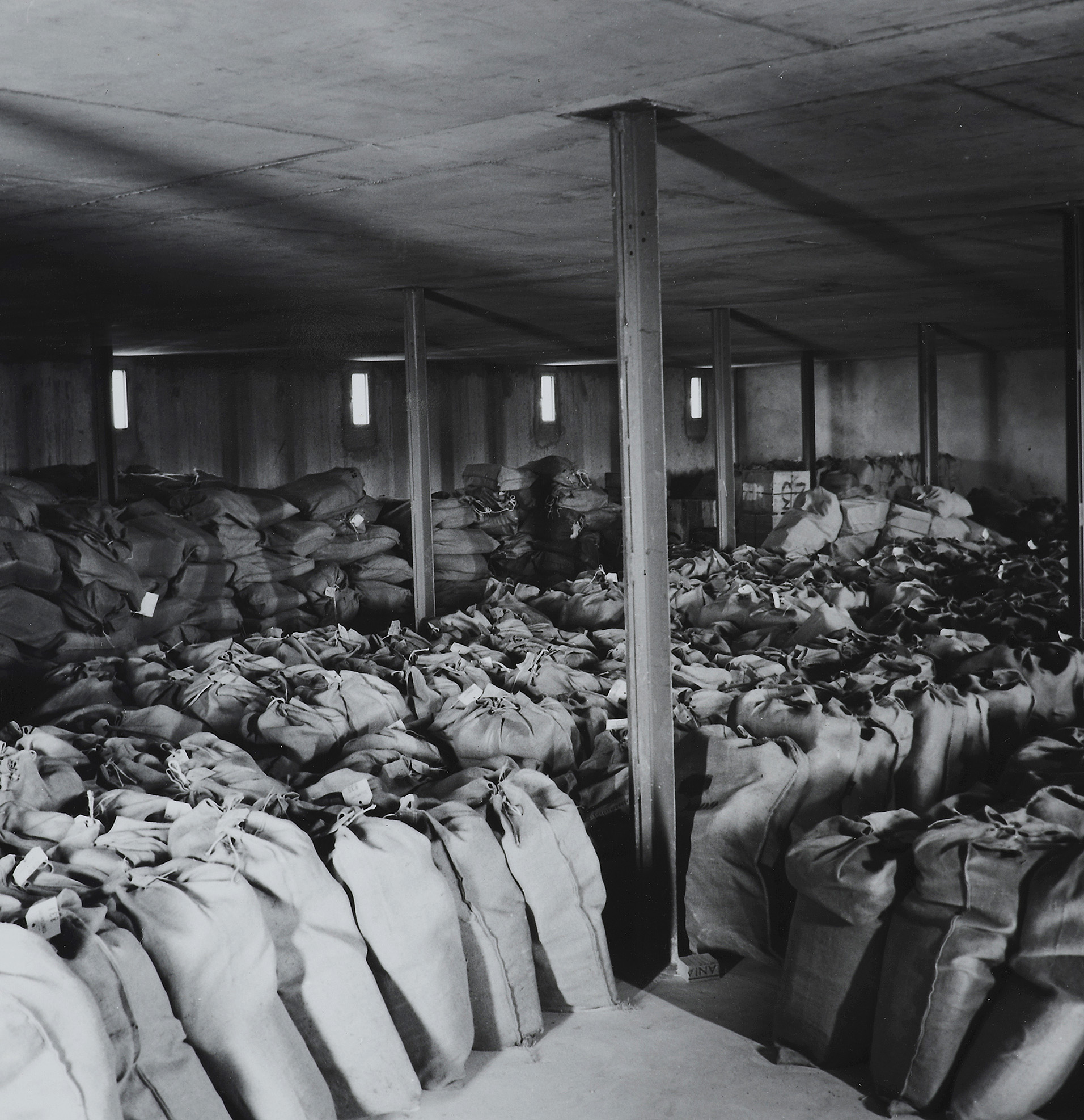 Expo ANOM dans la cité : photos des sacs entreposés en 1966 - Etat de conservation des archives rapatriées dans le dépôt, 1966  © ANOM
